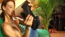 Frau auf grünem Sofa reibt sich zwischen den Beinen